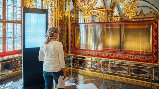 Eine Besucherin schaut in die ausgeraubte und nun ausgestellte Vitrine im Juwelenzimmer des Historischen Grünen Gewölbes im Residenzschloss (Quelle: dpa-Zentralbild/Oliver Killig)