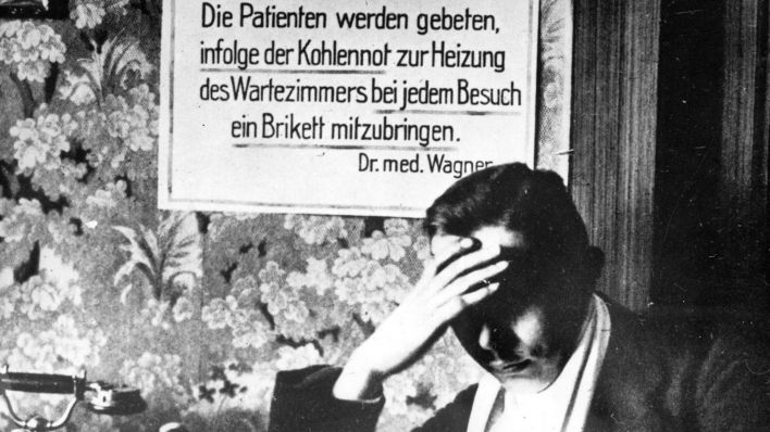 Archivbild: Das Archivbild von 1923 zeigt ein Schild und einen sitzenden Mann in einem Wartezimmer des deutschen Arztes Dr.med.Wagner. Aufgrund der Kohlenknappheit während der Inflation im Jahr 1923 wurden die Patienten gebeten, bei ihrem Besuch ein Brikett mitzubringen, um das Wartezimmer zu heizen. Vor 75 Jahren stiegen in Deutschland die Preise rapide an. In Berlin kletterte der Preis für ein Kilogramm Butter von 2,60 Mark vor dem ersten Weltkrieg auf 5,6 Billionen Mark im November 1923. Mit dem rapiden Verfall des Geldwertes sank der Lebensstandard breiter Bevölkerungsschichten dramatisch. (Quelle: dpa/Bildfunk)