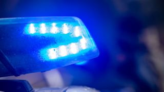 Ein Blaulicht leuchtet auf dem Dach eines Polizeifahrzeugs. (Quelle: dpa/Stefan Sauer)