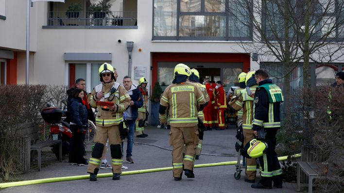 Einsatzkräfte der Feuerwehr stehen am 05.02.2023 bei einem Einsatz vor dem Eingang des Pflegeheims in Hakenfelde (Quelle: dpa/Carsten Koall)