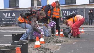 Klima-Demonstranten der Gruppe Letzte Generation schütten am 15.02.2023 Beton auf die Fahrbahn in Berlin (Quelle: dpa/Paul Zinken)