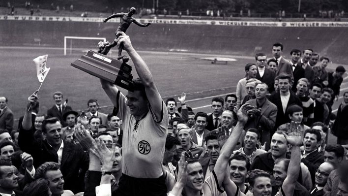 Ein Spieler des SC Tegel stemmt nach dem Sieg im Finale um die Deutsche Amateurmeisterschaft 1962 den Pokal in die Luft (imago images/Otto Krschak)