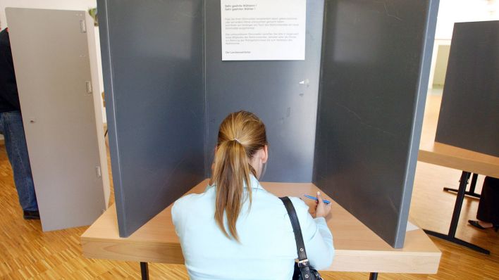 Eine junge Wählerin sitzt in der Wahlkabine (Symbolbild) (Quelle: imago images/photothek)