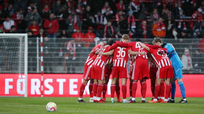 Die Spieler des 1. FC Union Berlin bilden einen Kreis vor dem Spiel, im Vordergrund liegt der Ball (Bild: Imago Images/Contrast)