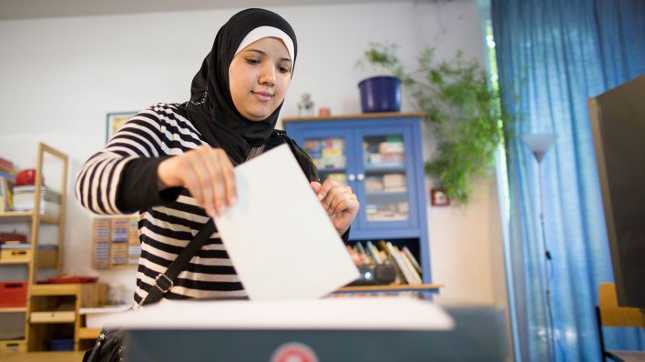 Symbolbild: Eine Wählerin gibt in einem Wahllokal in Kreuzberg in Berlin ihren Stimmzettel ab (Quelle: dpa/Maja Hitij)