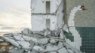 Gekacheltes Wandbild mit Schwanenhals-Abbildung ergänzt sich mit Trümmern eines zerstörten Hauses. (Quelle: privat/M. Maleschka)