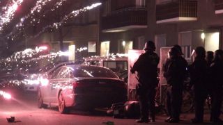 Die Polizeimitarbeiter schützen sich in der Silvesternacht vor einem schießenden Feuerwerk (Quelle: TV News Kontor)