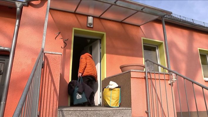 Eine Person mit Taschen betritt eine Flüchtlingsunterkunft in Brandenburg. (Quelle: rbb)