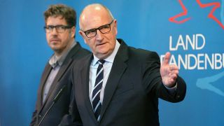 Archiv: Brandenburgs Ministerpräsident Dietmar Woike (SPD) gestikuliert. Links neben ihm steht Staatssekretär Michael Kellner (Grüne). (Foto: Soeren Stache/dpa)