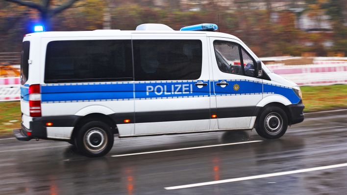 Symbolbild: Ein Mannschaftswagen der Polizei fährt am 05.12.2022 bei einem Einsatz mit Blaulicht über eine nasse Strasse in Berlin. (Quelle: dpa/Wolfram Steinberg)
