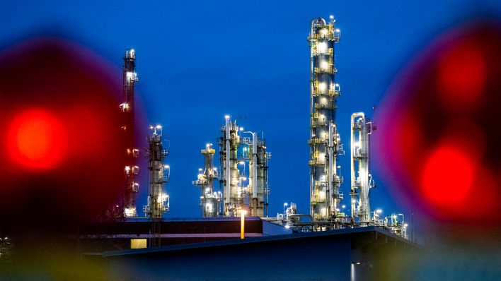 Symbolbild: Die Anlagen der Erdölraffinerie auf dem Industriegelände der PCK-Raffinerie GmbH sind abends beleuchtet. (Quelle: dpa/Christophe Gateau)