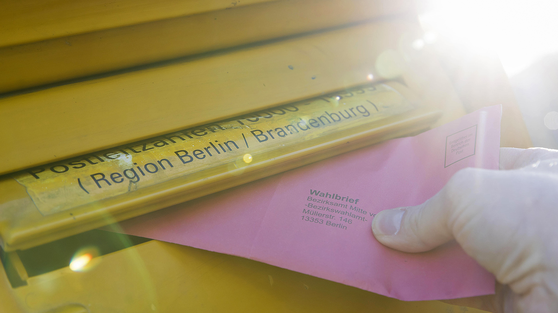 Symbolbild: Einwurf roter Wahlbriefumschlag in Briefkasten der Deutschen Post für die bevorstehende Wiederholungswahl zum Berliner Abgeordnetenhaus am 12.02.2023. (Quelle: dpa/Ben Kriemann)