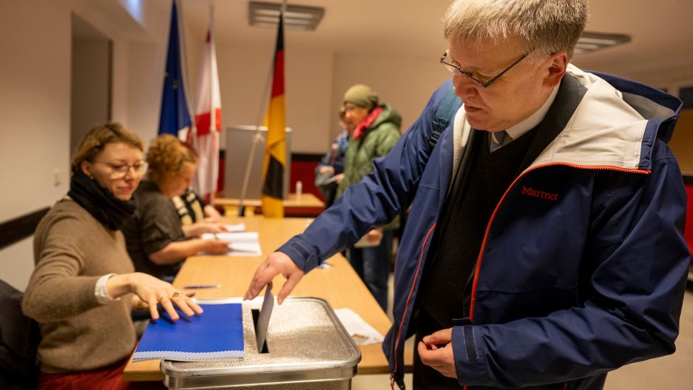 Stephan Bröchler, Landeswahlleiter, wirft am 12.02.2021 in einem Wahllokal seinen Stimmzettel in die Wahlurne. (Quelle: dpa/Monika Skolimowska)