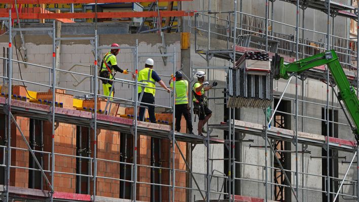 Symbolbild:Vier Arbeiter stehen auf dem Baugerüst der Baustelle am Alten Markt in der Potsdamer Innenstadt.(Quelle:dpa/S.Stache)