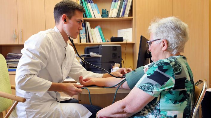 Ein Medizinstudent untersucht eine Patientin. (Quelle: dpa/Bernd Wüstneck)