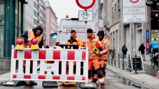 Arbeiter stellen eine Absperrung an der Einfahrt zur Friedrichstraße, Ecke Leipziger Straße auf. (Quelle: dpa/Carsten Koall)