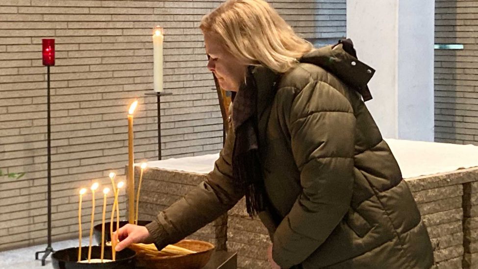 Bundesinnenministerin Nancy Faeser (SPD) zündet am Ende einer Friedensandacht am Jahrestag des Angriffskriegs auf die Ukraine eine Kerze an. (Quelle: dpa/Thomas Struk)