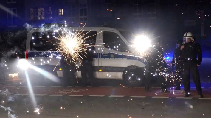 Archivbild: Polizeibeamte stehen in der Silvesternacht hinter explodierendem Feuerwerk. (Quelle: dpa/J. Schreiner)
