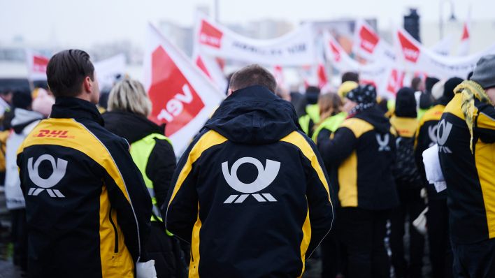 Das Post-Logo steht auf den Jacken der Demonstranten der Deutschen Post, die vor der Ver.di Bundeszentrale auf der Schillingbrücke streiken. Sie fordern 15 Prozent mehr Lohn für Postangestellte. (Quelle: dpa/A. Riedl)