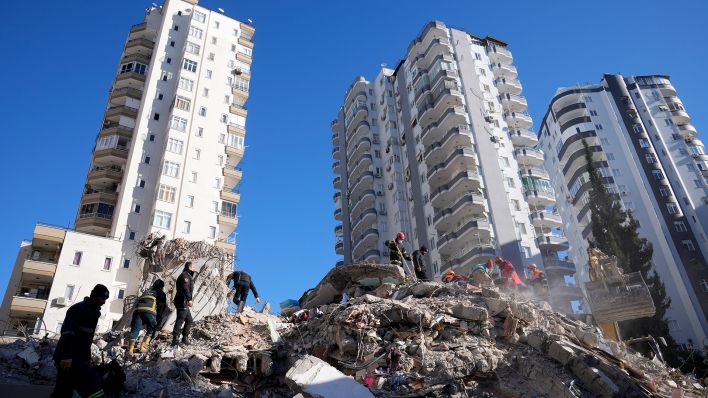 Notfallteams suchen nach Menschen in den Trümmern eines zerstörten Gebäudes. (Quelle: dpa/H. Malla)