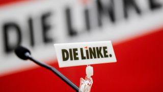 Das Logo der Partei Die Linke ist bei einem Sonderparteitag der Berliner Linken an einem Mikrofon zu sehen. (Quelle: dpa/Christoph Soeder)