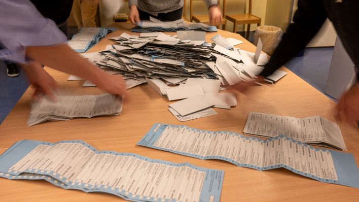 Wahlhelfer sortieren nach der wiederholten Wahl die Stimmzettel in einem Wahllokal in der Grundschule am Teutoburger Platz in Prenzlauer Berg. (Bild: dpa-news/Monika Skolimowska)