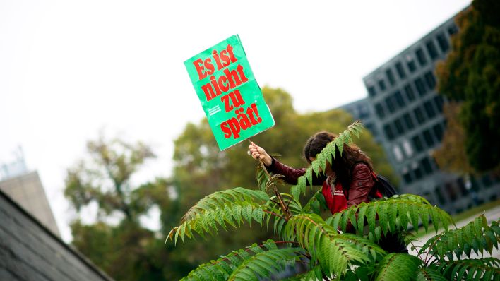 Symbolbild:Eine Aktivistin des Volksbegehrens hält ein Schild mit der Aufschrift "Es ist nicht zu spät" hoch.(Quelle:imago images/S.Boness/Ipon)