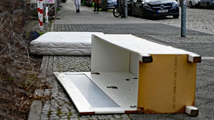 Eine ausrangierte Matratze und ein beschädigter Schrank liegen auf einem Gehweg. (Quelle: dpa/Philipp Znidar)