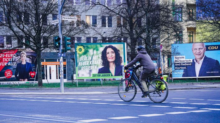 Eine Radfahrerin fährt an Wahlplakaten von SPD, Grünen und CDU für die Wiederholungswahl in Berlin vorbei. (Quelle: imago-images/Political-Moments)