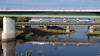 Eine Regionalbahn der Niederbarnimer Eisenbahn NEB der Linie RB 26 fährt am 15.10.2019 über eine Brücke und spiegelt sich im Wasser der Oder. (Quelle: dpa-Zentralbild/Soeren Stache)