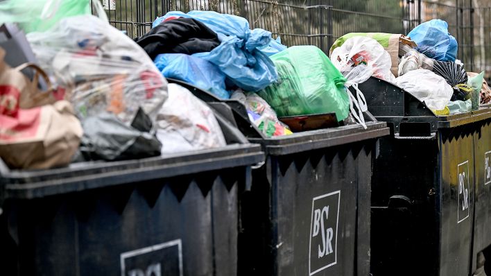 Überfüllte Mülltonnen stehen am 06.03.2023 in einer Wohnsiedlung. Verdi macht in Berlin mit weiteren Warnstreiks Druck im Tarifstreit des öffentlichen Diensts. (Quelle: dpa-Bildfunk/Britta Pedersen)
