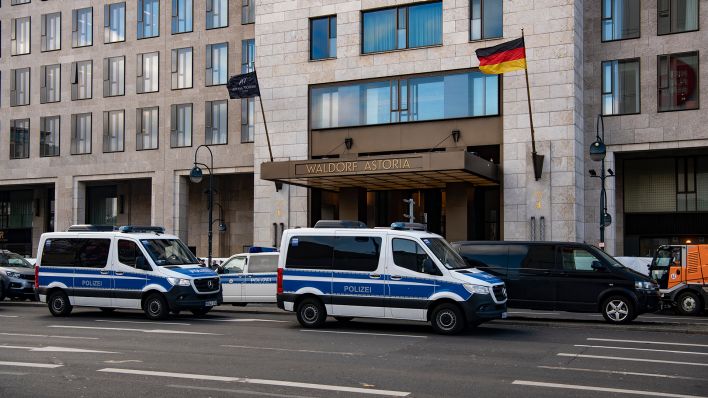 Einsatzfahrzeuge der Polizei stehen am 15.03.2023 in dem für Verkehr gesperrten Bereich am Hotel Waldorf Astoria. (Quelle: dpa/Paul Zinken)