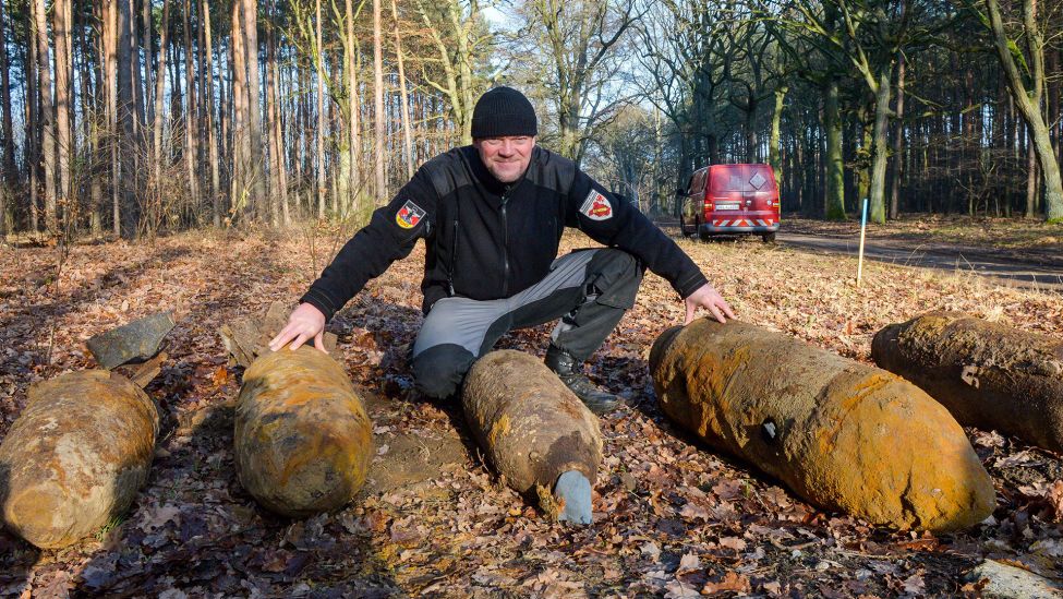 Sprengmeister Mike Schwitzke hockt am 21.12.2016 im Potsdamer Wildpark (Brandenburg) neben fünf entschärften Fliegerbomben. (Quelle: dpa/Julian Stähle)