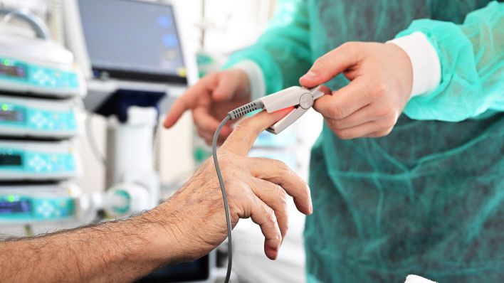 Symbolbild:Ein Pfleger legt bei einem Patienten ein Messgerät an.(Quelle:dpa/B.Weißbrod)