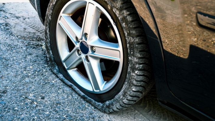 Symbolbild: Ein platter Reifen an einem Auto (Bild: dpa/Christian Ohde)