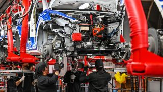 Mitarbeiter der Tesla Gigafactory Berlin Brandenburg arbeiten an einer Fertigungslinie eines Elektrofahrzeuges vom Typ Model Y am 20.03.2023.(Quelle:dpa/P.Pleul)
