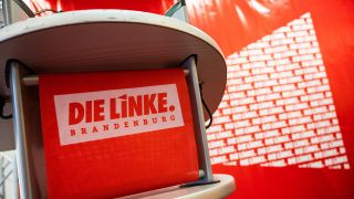 Beim Landesparteitag der Linken Brandenburg steht ein Rednerpult mit dem Logo der Partei. (Quelle: dpa/Christophe Gateau)