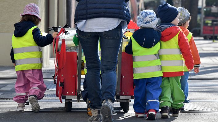 Symbolbild: Ein Betreuerin läuft mit mehreren Kleinkindern über einen Bürgersteig. (Quelle: dpa/P. Kneffel)