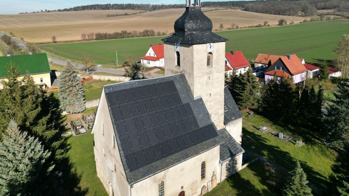 Symbolbild: Solarmodule sind auf dem Dach einer Kirche befestigt. (Quelle: dpa/B. Schackow)