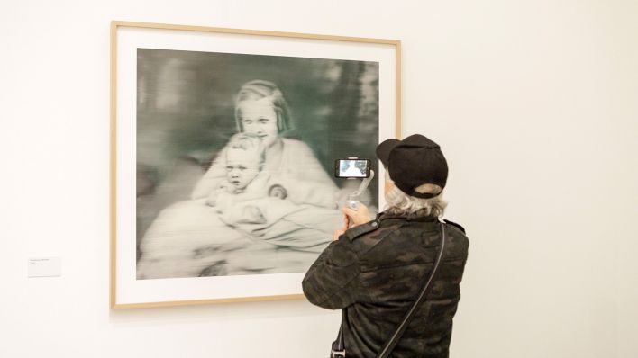 Ein Mann filmt in der Ausstellung «Gerhard Richter. 100 Werke für Berlin» in der Neuen Nationalgalerie das Werk "Tante Marianne", das den Künstler als Baby und seine Tante, die von Nazis ermordet wurde, zeigt. (Quelle: dpa/J. Schreiner)