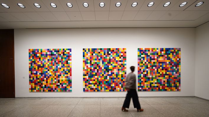 Eine Besucherin geht in der Ausstellung "100 Werke für Berlin" des Künstlers Gerhard Richter an den Werken "4900 Farben" in der Neuen Nationalgalerie vorbei. (Quelle: dpa/J. Carstensen)