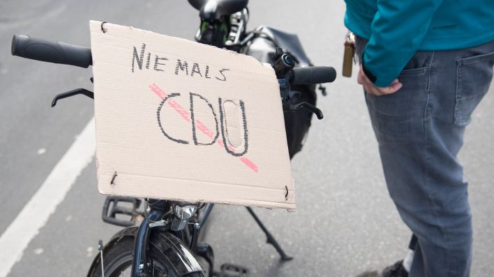 Teilnehmer an einer Demonstration gegen eine CDU-SPD-Regierung in Berlin hat ein Schild mit der Aufschrift "Niemals CDU" an seinem Fahrrad angebracht. (Quelle: dpa/Paul Zinken)