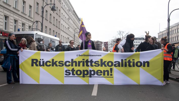 Teilnehmer halten ein Banner mit der Aufschrift «Rückschrittskoalition stoppen!» während einer Demonstration gegen eine CDU-SPD-Regierung in Berlin. (Quelle: dpa/Paul Zinken)