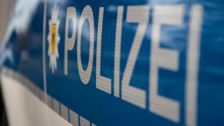 Symbolbild: Schriftzug an Polizeiwagen in Nahaufnahme. (Quelle: dpa/Andreas Gora)