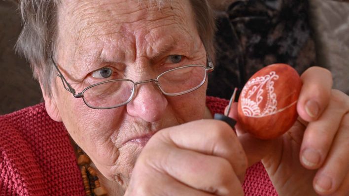Renate Radoy sitzt in ihrer Wohnung und gestaltet mit einem Gravurstift ein Osterei. Die 91 Jahre alte Kunsthandwerkerin beweist trotz ihres hohen Alters eine erstaunlich ruhige Hand: Sie graviert Muster, Motive oder Gedichte in Eierschalen. Ist nicht gerade Osterzeit, engagiert sich die gebürtige Berliner auf vielen Ebenen für ihre Wahlheimat. (Foto: dpa)