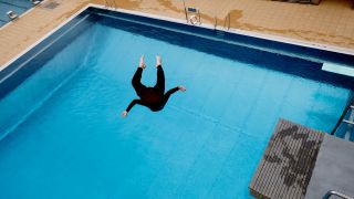 Ein Mann springt am 29.04.2023 vom Sprungturm im Sommerbad Olympiastadion. (Quelle: dpa/Carsten Koall)