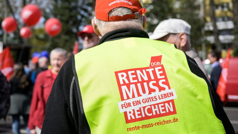 Ein Demonstrationsteilnehmer trägt am 1.05.2023 eine Weste mit der Aufschrift „Rente muss für ein gutes Leben reichen":(Quelle:dpa/H.P.Albert)