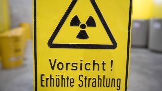 Symbolbild:Ein Warnschild "Radioaktiv - Vorsicht! Erhöhte Strahlung" steht auf einem Gelände eines Atomkraftwerks.(Quelle:dpa/S.Sauer)