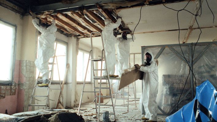Symbolbild: Schutzanzüge und Schutzmasken geben wirksame Sicherheit beim Abriß der Asbestplatten. (Quelle: dpa/T. Lehmann)