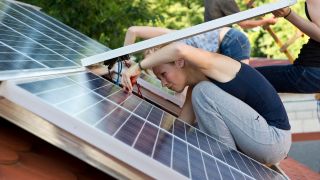 Frau installiert eine Solaranlage (Quelle: dpa/Daniel Schoenen)